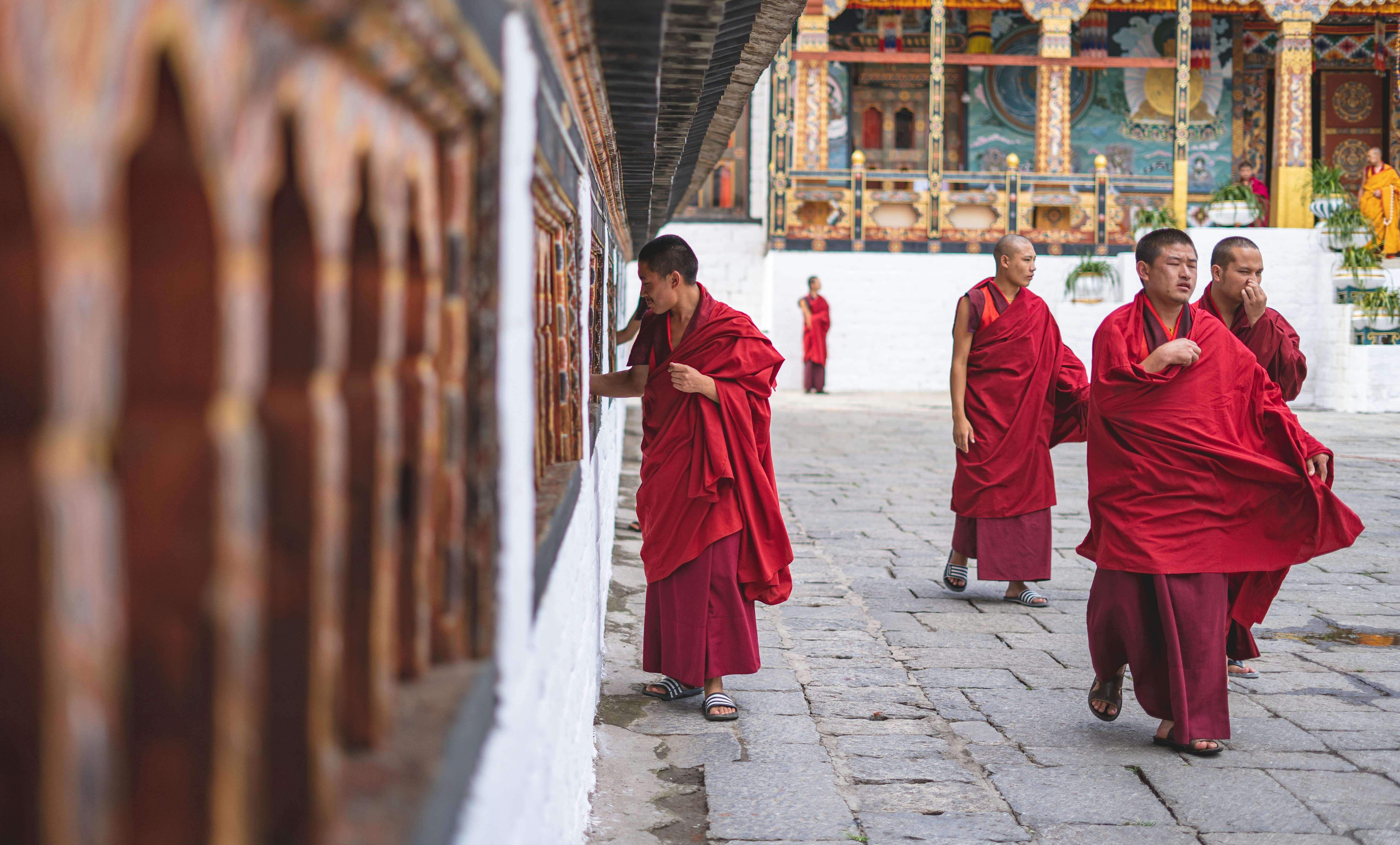 a monk rotating the prayer wheel in bhutan