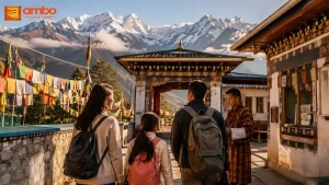 Indian travellers with luggage arriving in Bhutan, with prayer flags and Himalayan mountains in the background